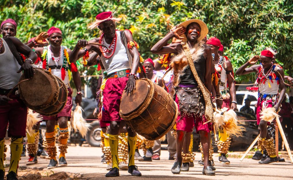 A group of men in traditional costumes are playing drums